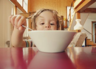 Enfant qui mange dans son assiette comme un grand