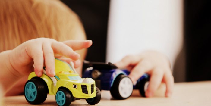 Enfant qui joue avec des petites voitures pour s'éduquer sur la prévention routière