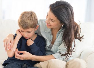 Maman qui met un pansement sur le bras de son fils qui s'est fait mal