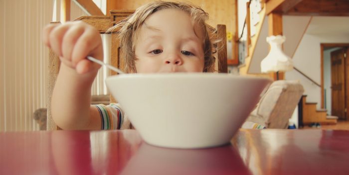 Enfant qui mange dans son assiette comme un grand