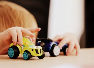 Enfant qui joue avec des petites voitures pour s'éduquer sur la prévention routière